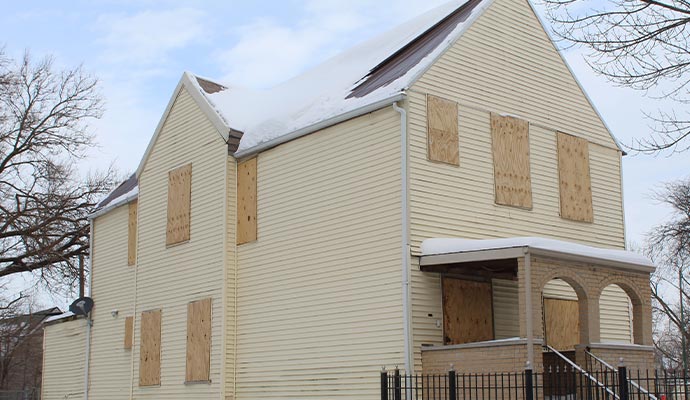 Boarded-up yellow house