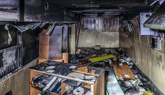 a room severely damaged by fire alongside its contents