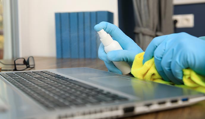 a person decontaminating an electronic device