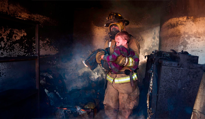 Firefighter Carrying Boy Fire Damage